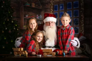 Children in pajamas giving Santa Claus a hug at a photo studio in Chattanooga